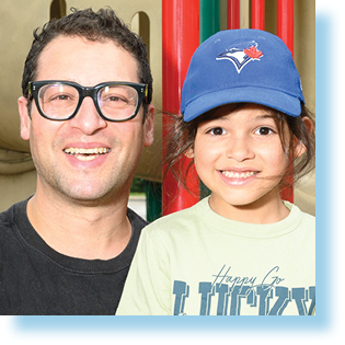 father and son smiling in a playground