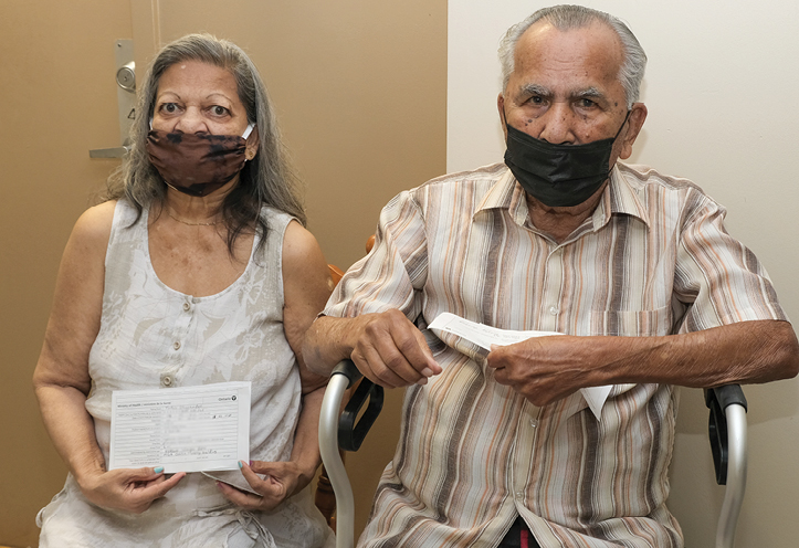 Man and woman sitting on chair and wearing masks