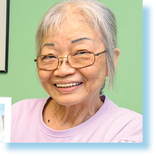 smiling elderly woman holding artwork