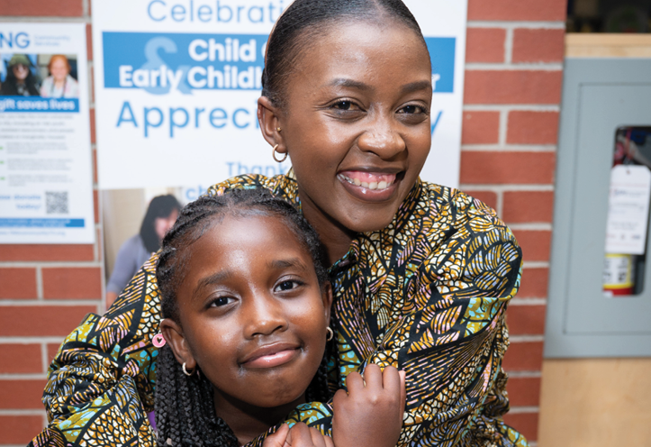 smiling woman holding her daughter