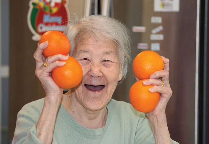 elderly woman holding oranges