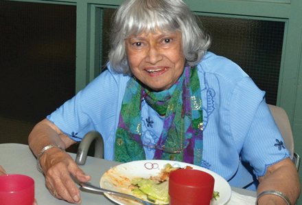 elderly woman eating at the community dinner