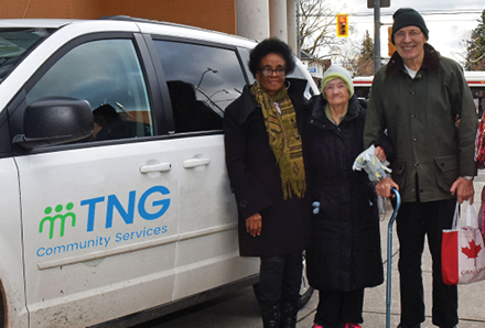 volunteer driver standing with seniors in front of TNG vehicle