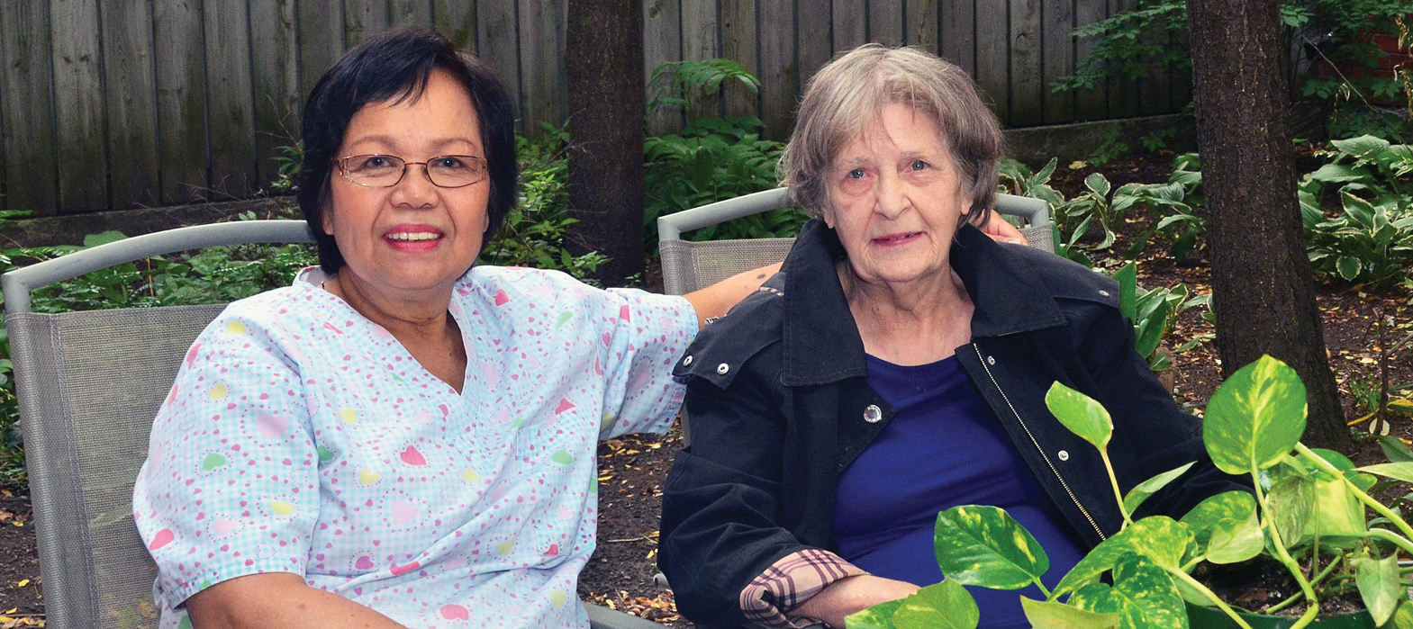 resident and caregiver in the Jean Dudley residence backyard