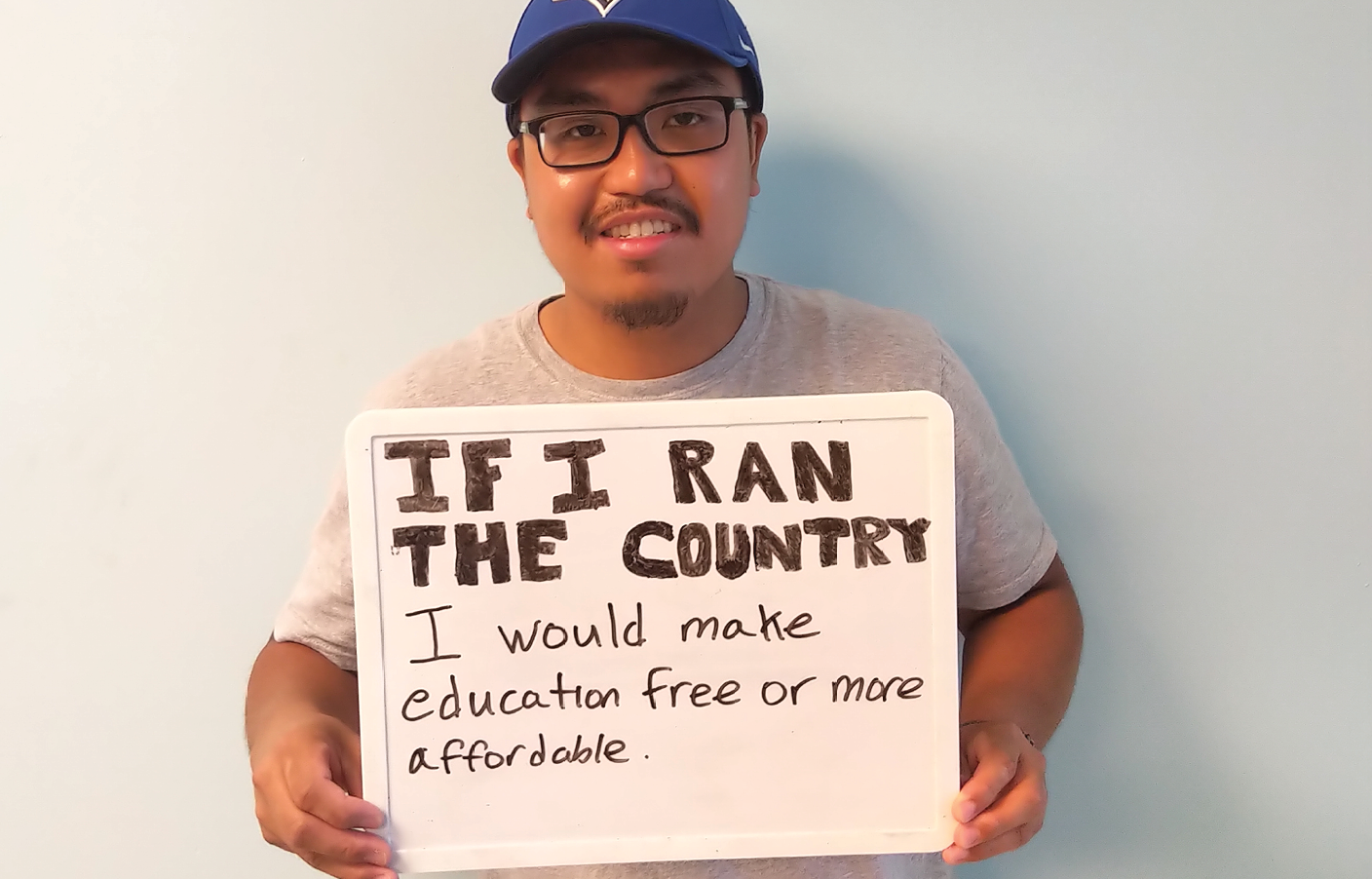 young man holding sign about affordable education